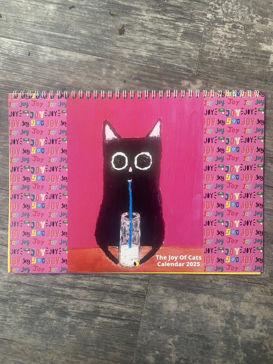 The Joy Of Cats" features artwork of a black cat drinking through a straw. The background is pink with repeated "JOY" text